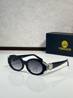 Sunglasses with black round frames, silver side emblem, dark lenses