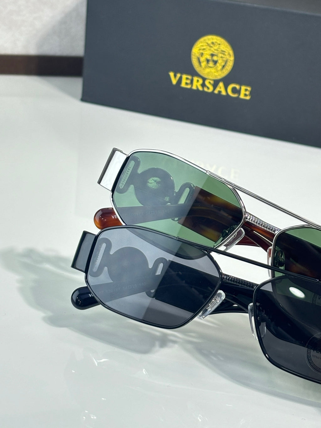 Sunglasses set with green and dark lenses, metal frames with bridge and temple details