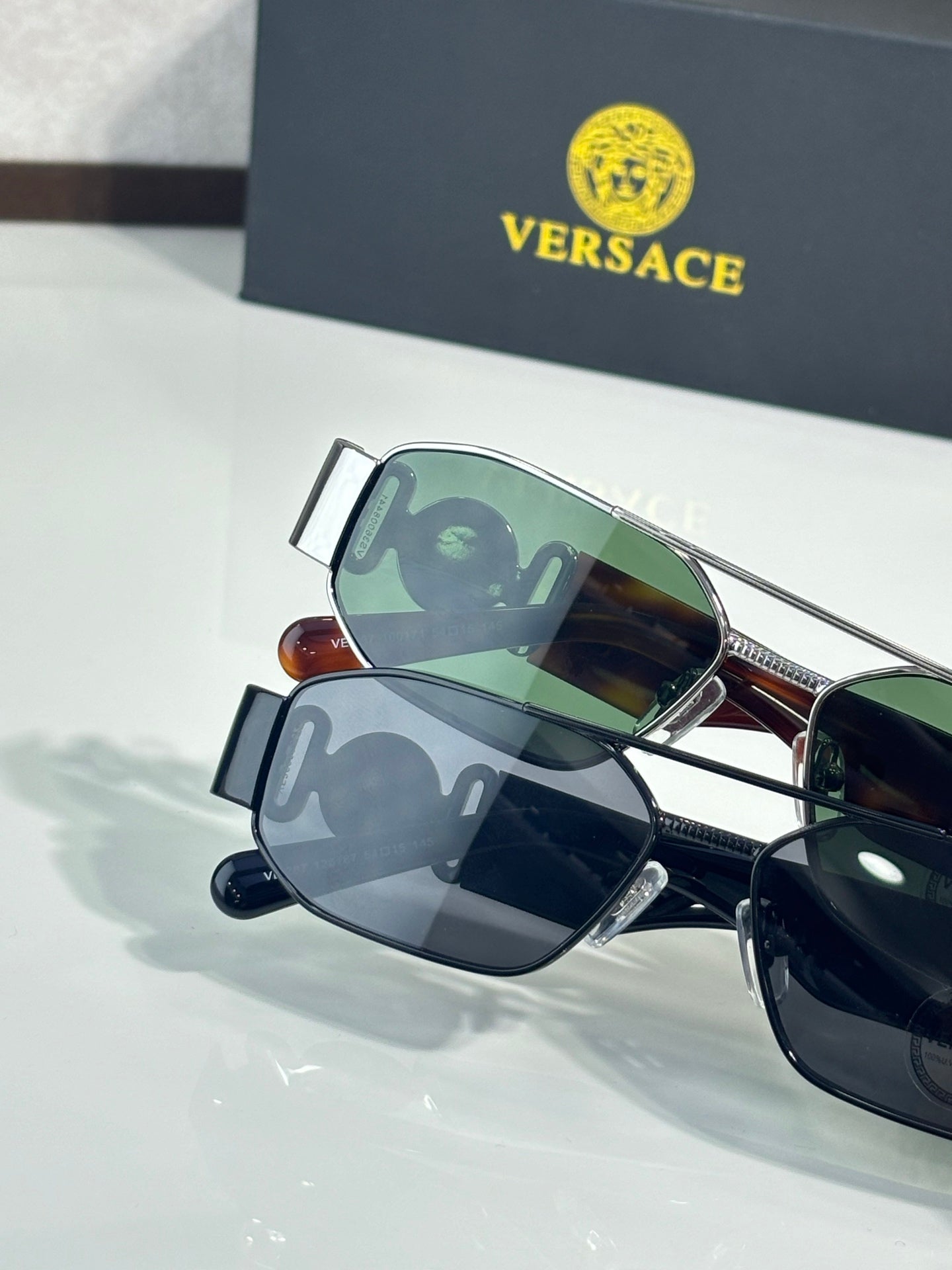 Sunglasses set with green and dark lenses, metal frames with bridge and temple details