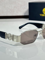 Sunglasses with silver metal frame and light brown tinted lenses, logo detail on temple