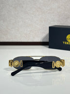 Sunglasses with dark navy frame and gold medallion-style temple accents