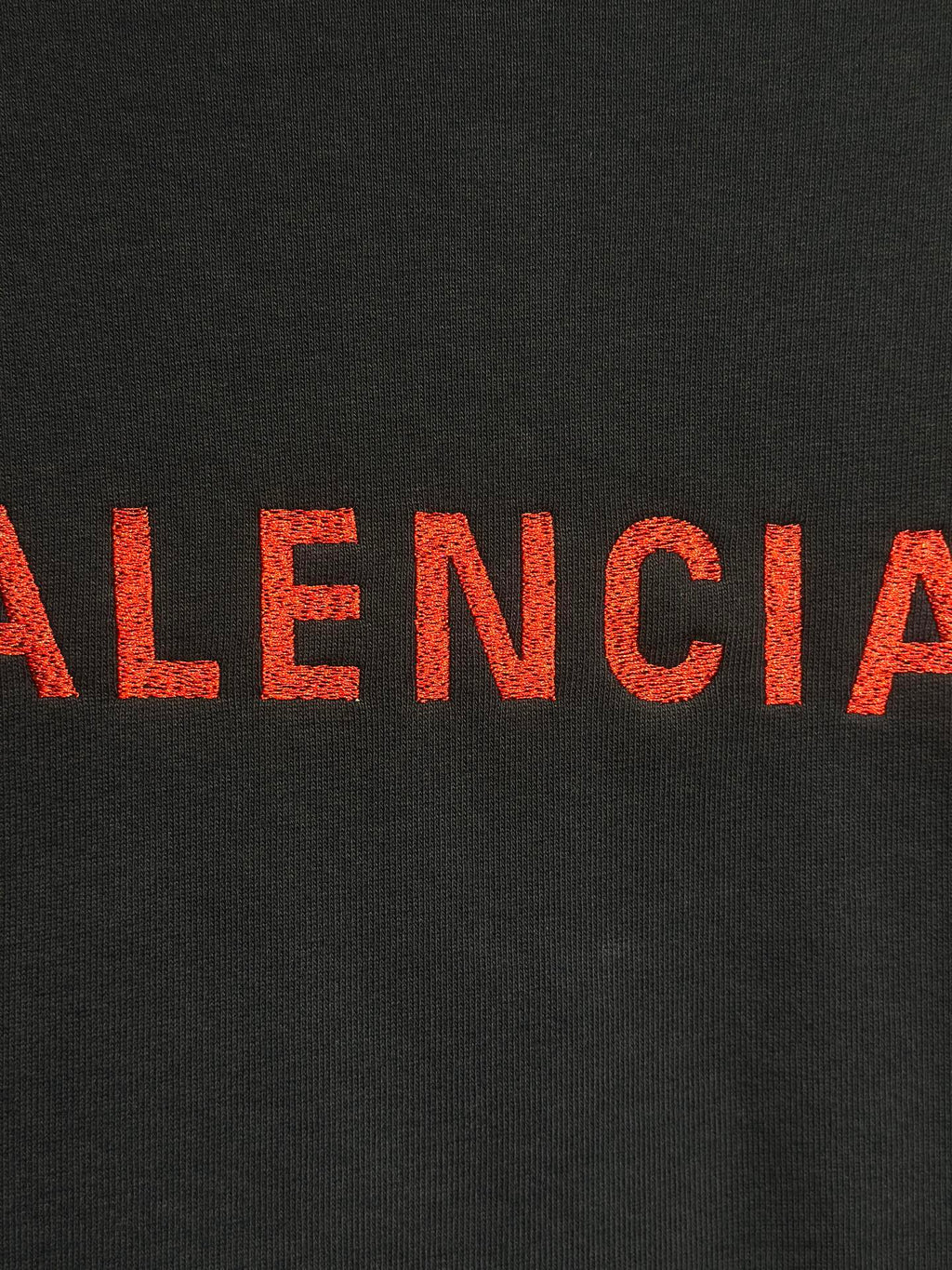 Dark hooded jacket with red Balenciaga lettering