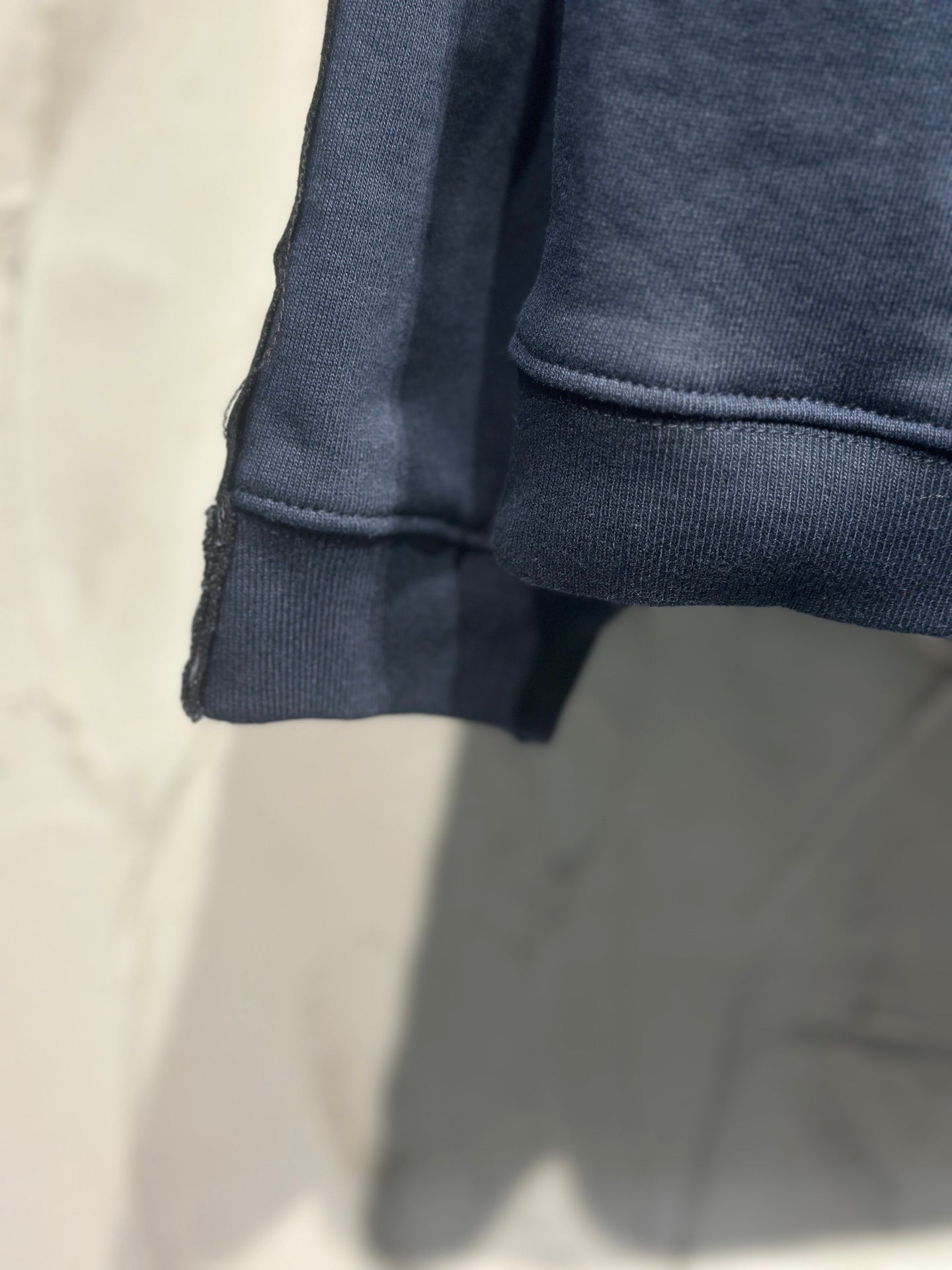 Long-sleeve dark denim top cuff and hem detail