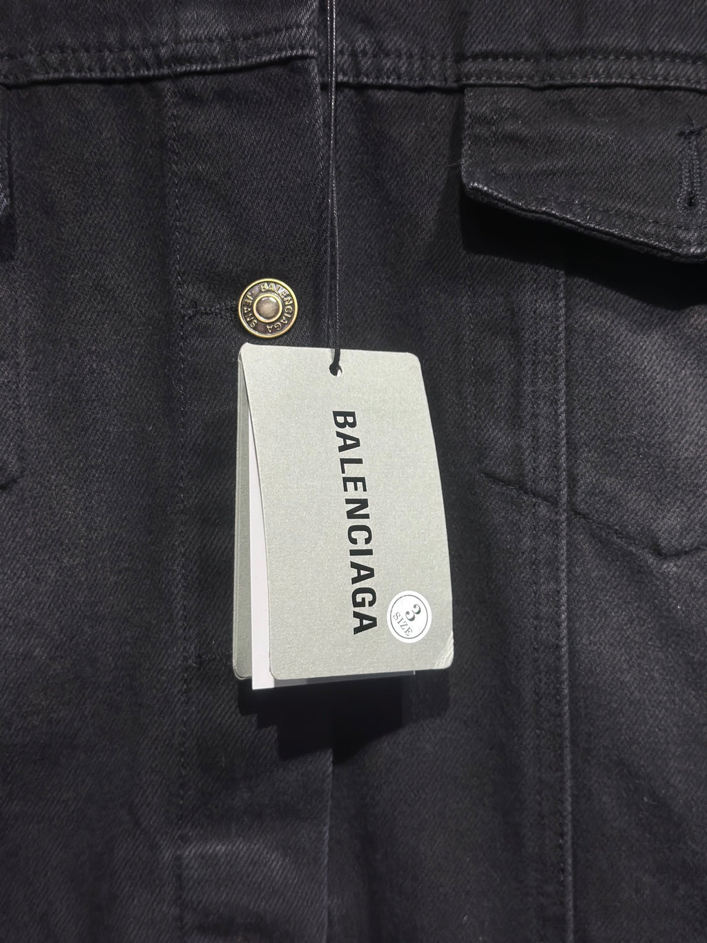 Balenciaga-branded size tag on dark denim hooded jacket
