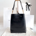 YSL black leather tote-style bag with top handles, gold hardware, and bow detail