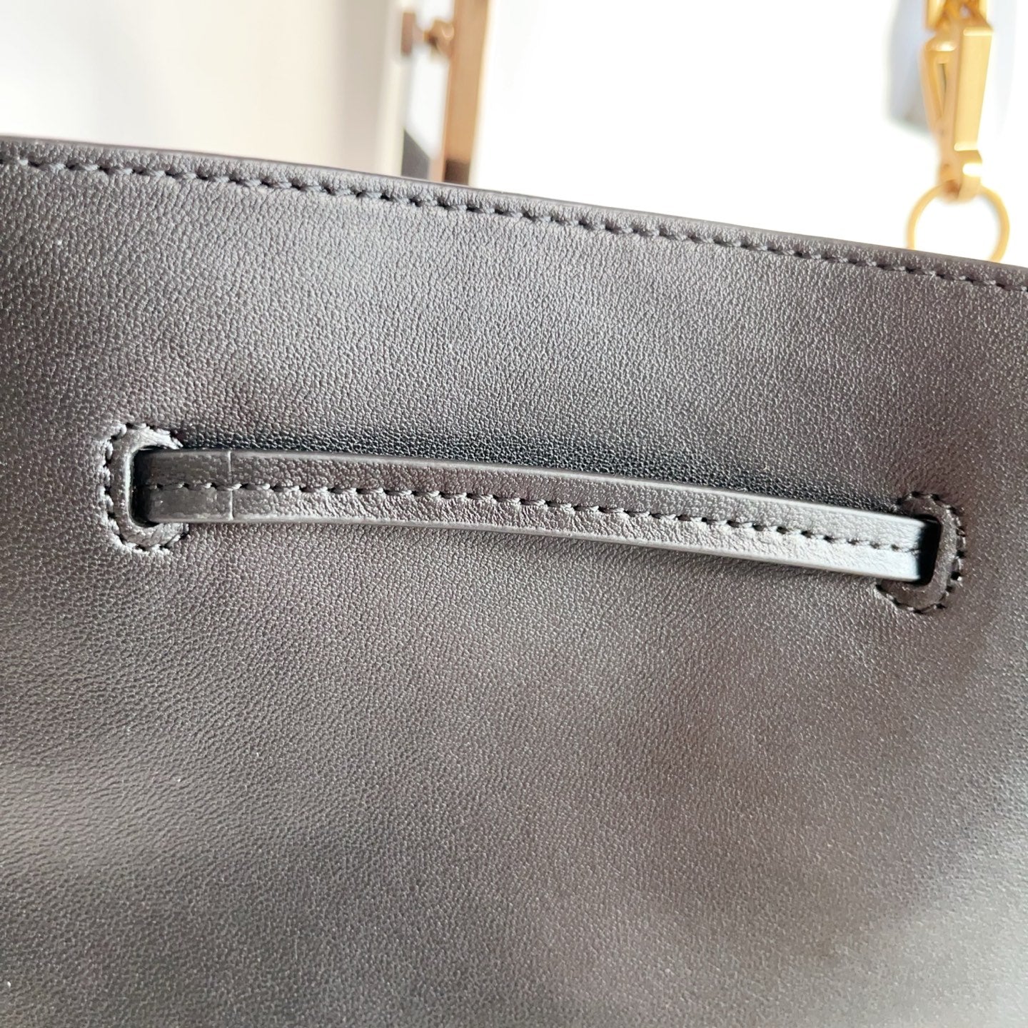 YSL black leather bag with stitched rectangular logo tab on the front