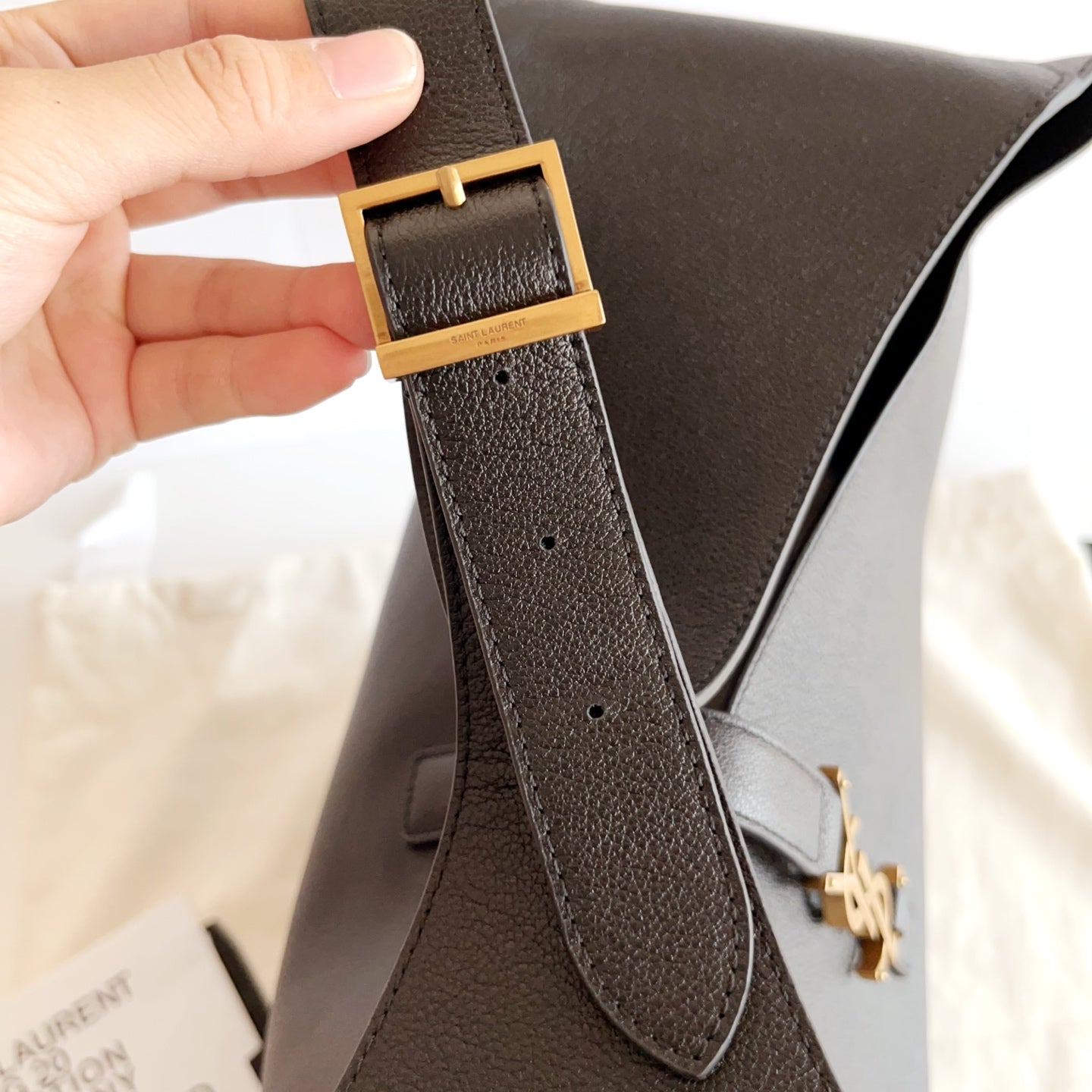 YSL black leather bag close-up of adjustable strap and gold-tone hardware