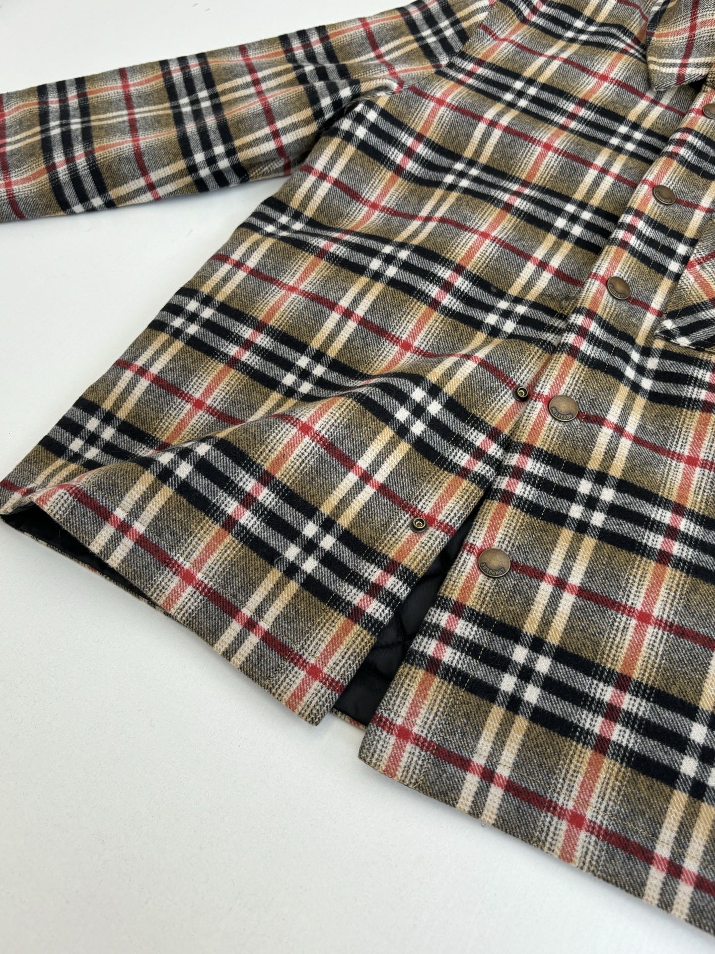 Burberry plaid shirt with split neckline and snap-button cuffs, folded close-up
