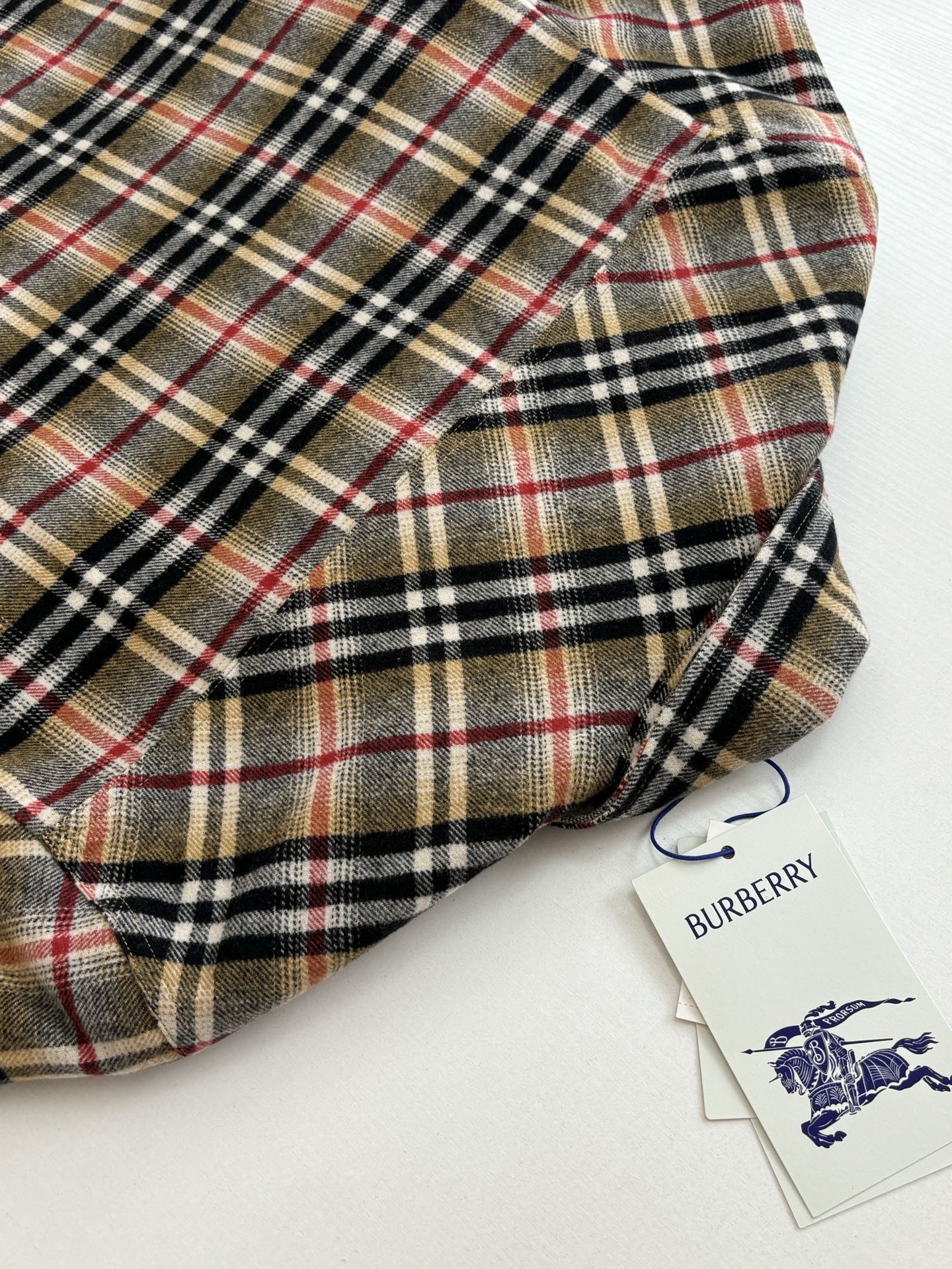 Burberry plaid long coat with buttoned front and rounded collar, tags attached