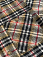 Burberry plaid fabric with metal buttons and pointed flap detail, close-up