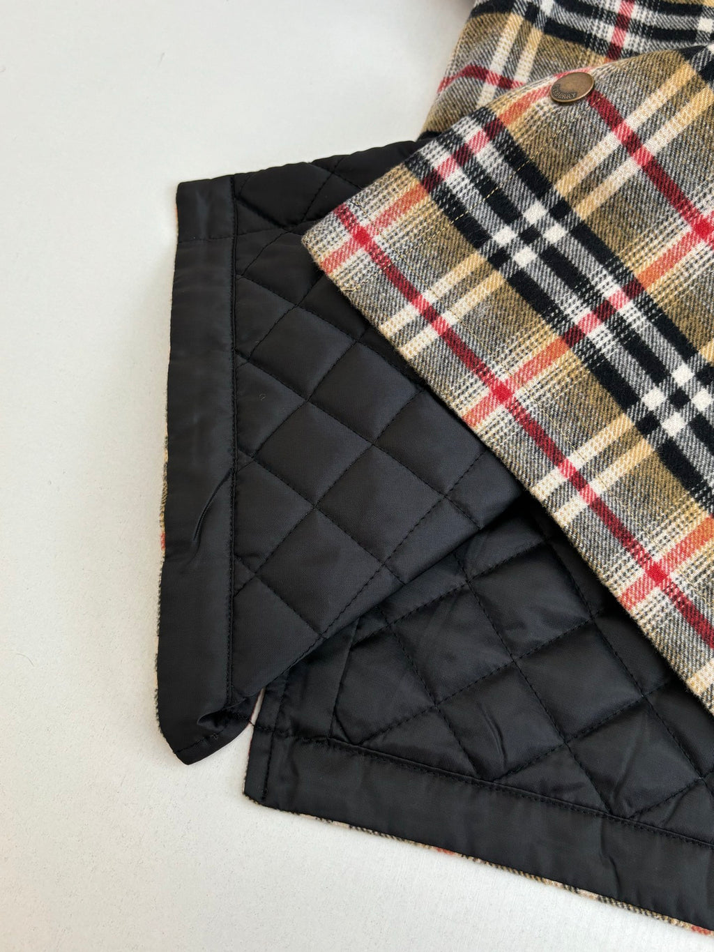 Burberry plaid shirt with black quilted lining panel, edge close-up