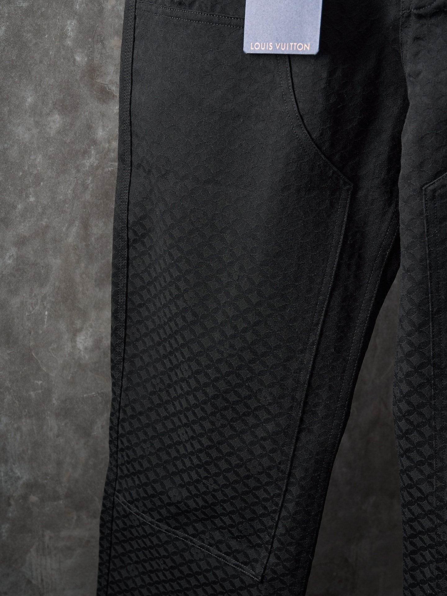 Louis Vuitton pants side view showing textured fabric panel and seam details