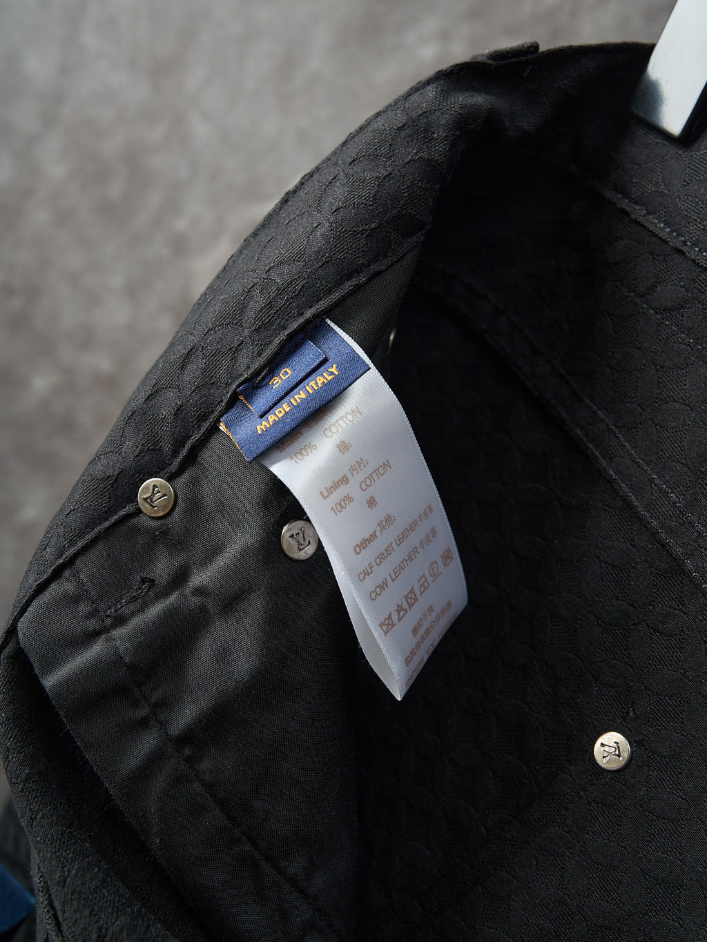Louis Vuitton pants close-up of inner waistband lining with stitched logo label and snap buttons