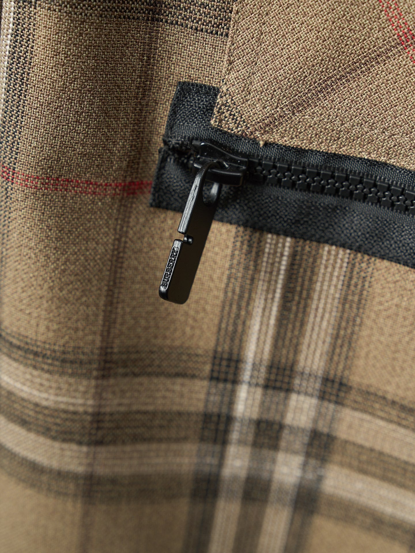 Burberry plaid pants with black zipper pull and woven fabric