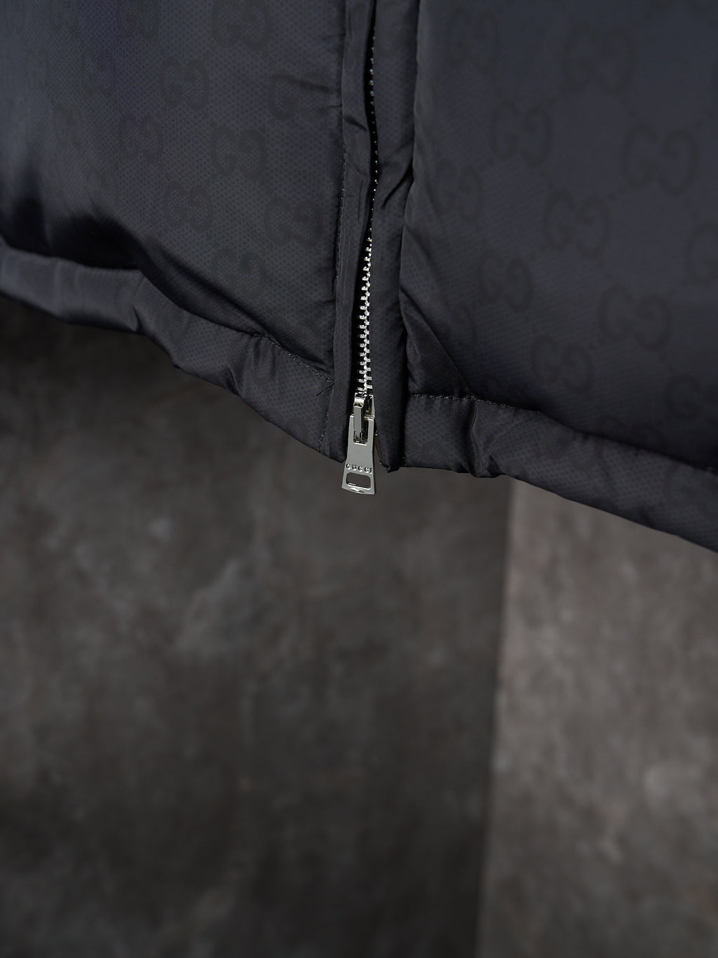 Gucci puffer jacket close-up of lower zipper seam, dark gray