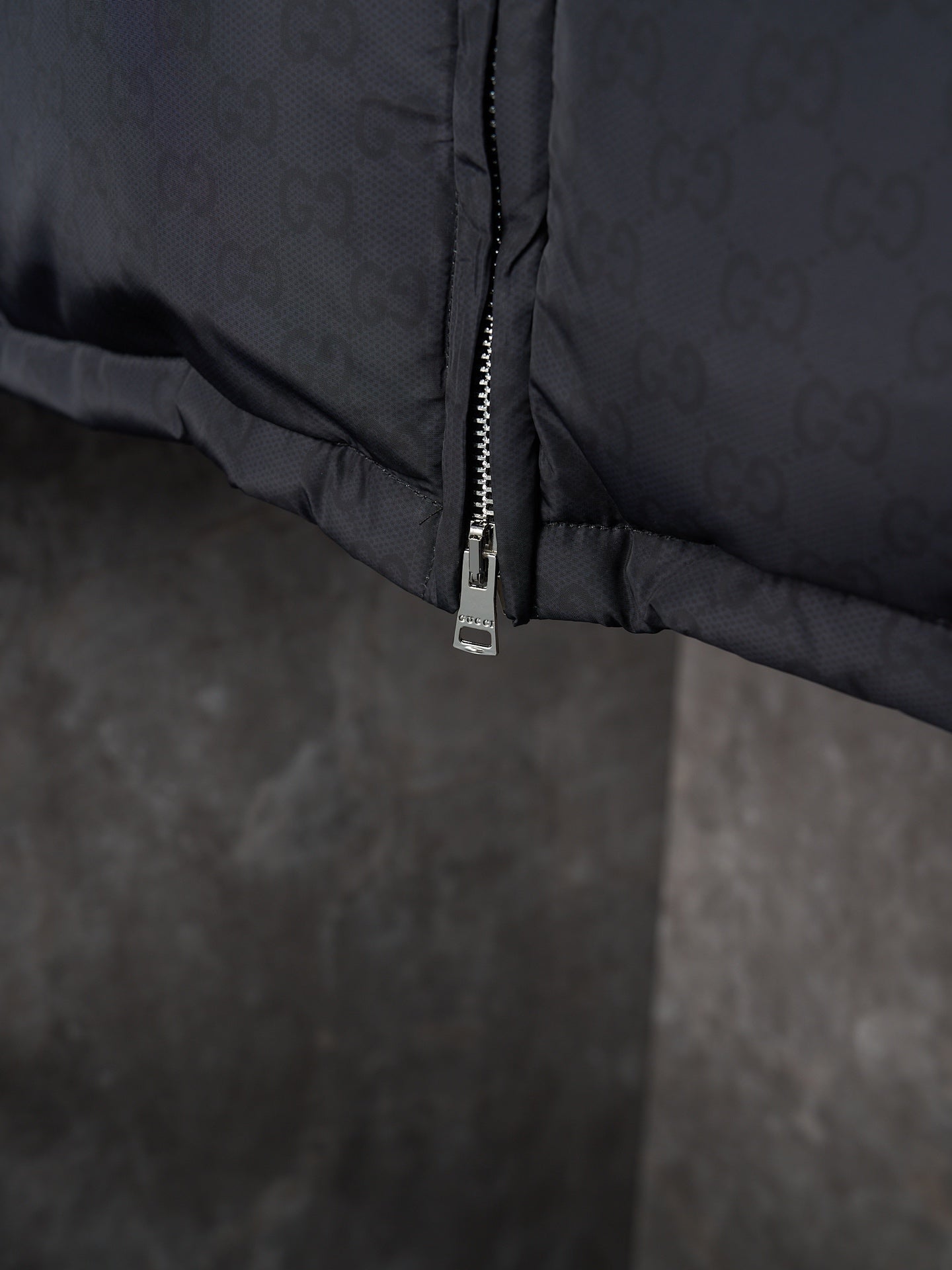 Gucci puffer jacket close-up of lower zipper seam, dark gray