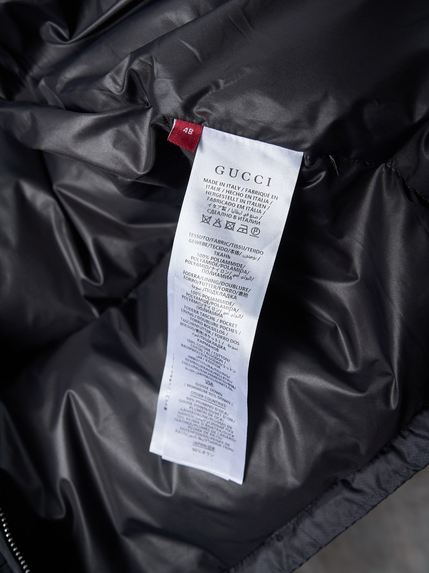 Gucci long jacket interior care label on black fabric