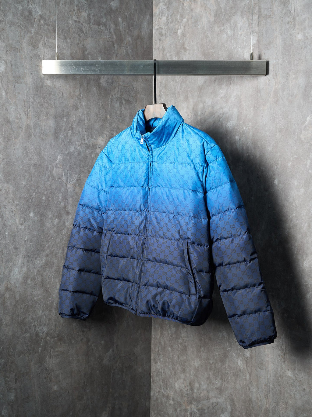 Blue puffer jacket with front zip and high collar, padded body and sleeves