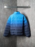 Blue puffer jacket back view with full-length quilting and hemline