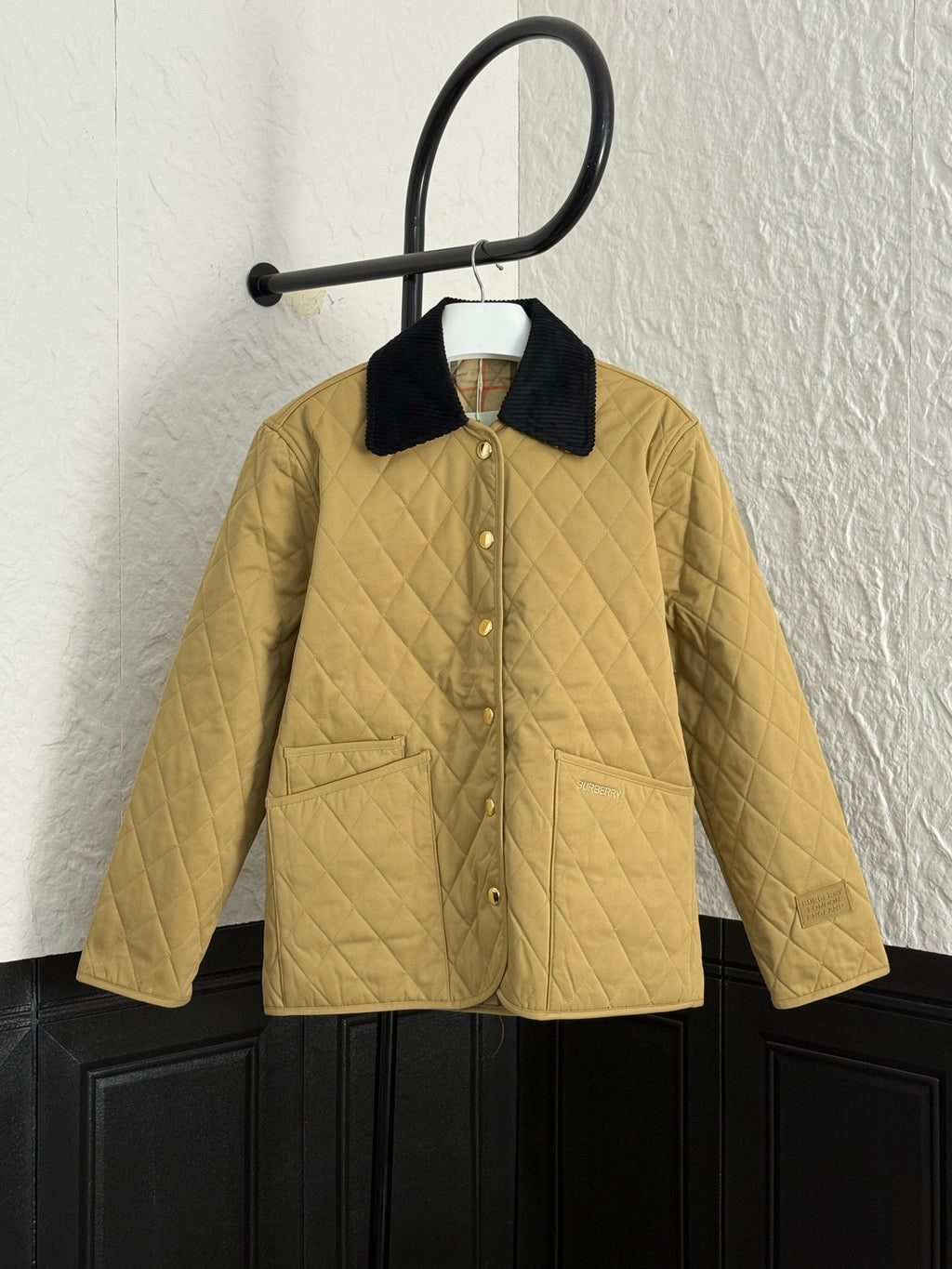 Burberry quilted jacket with black collar and button front, tan