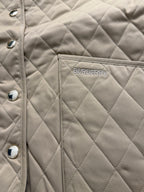 Tan quilted jacket with Burberry logo patch on chest and snap buttons