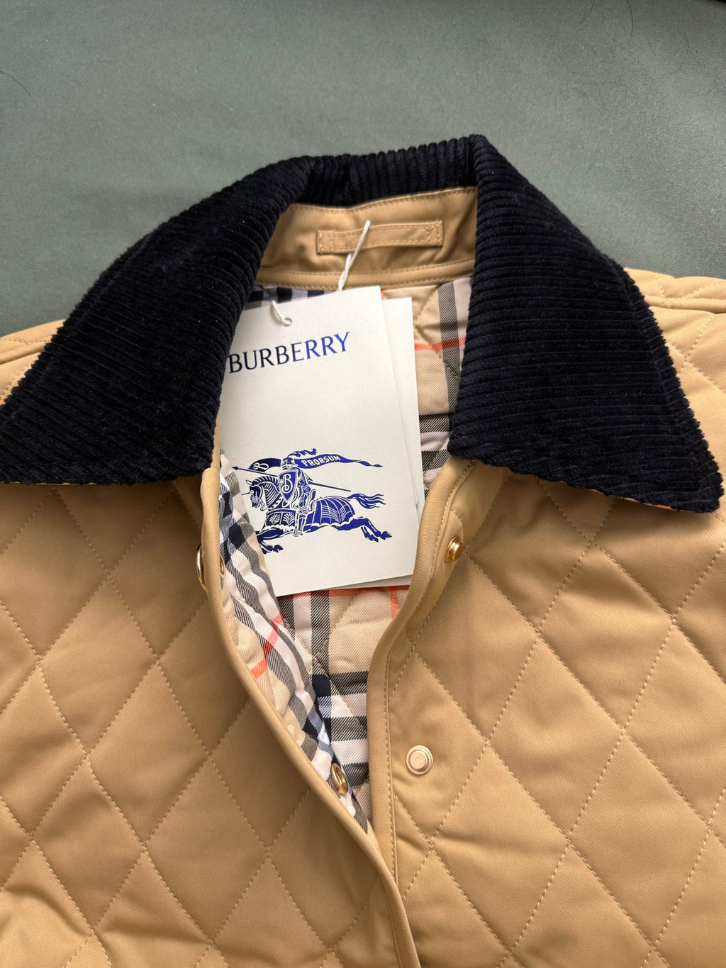 Burberry quilted jacket with black knit collar and plaid-lined interior