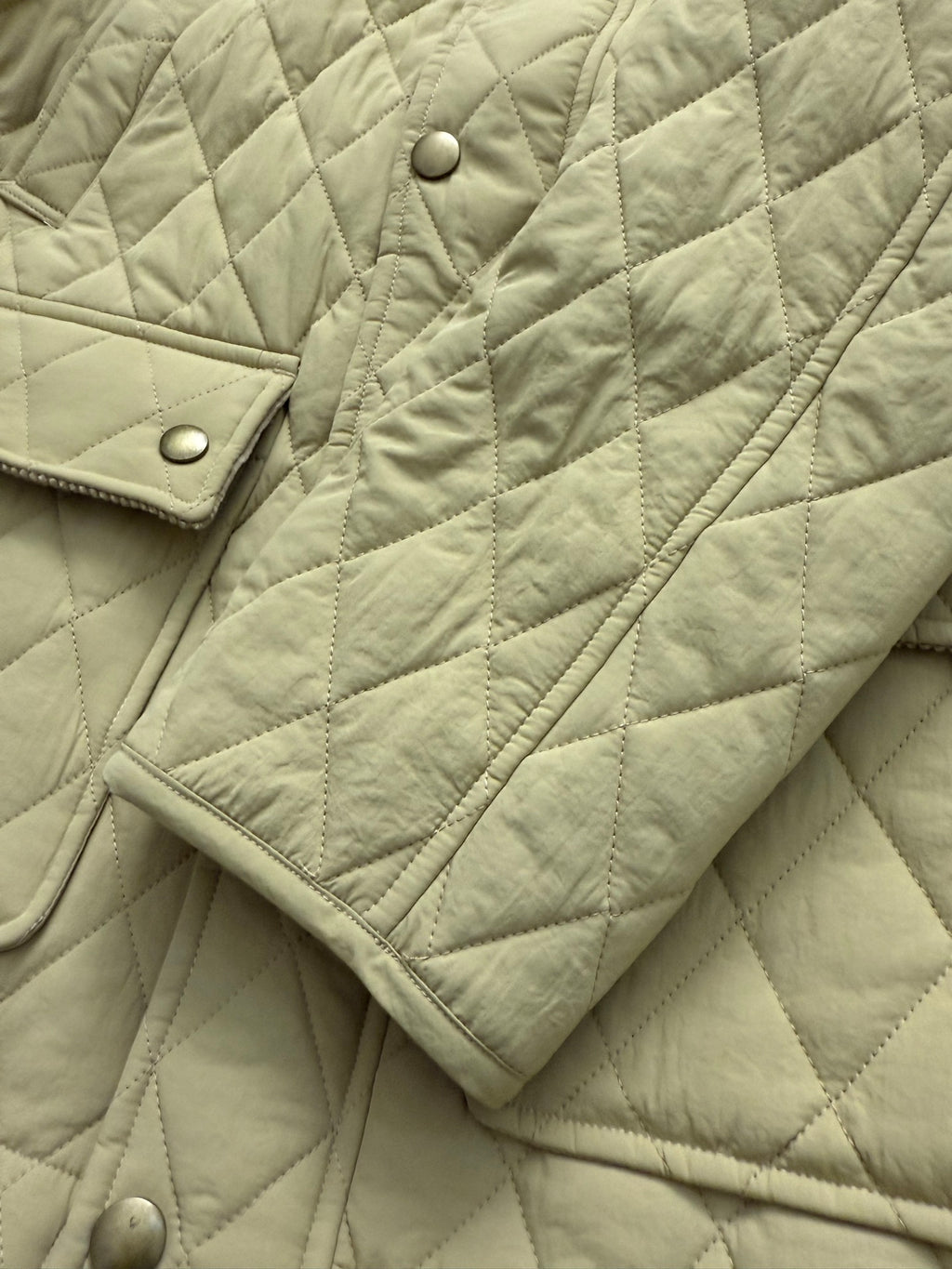 Light yellow quilted jacket sleeve with snap button placket detail