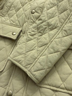 Light yellow quilted jacket sleeve with snap button placket detail