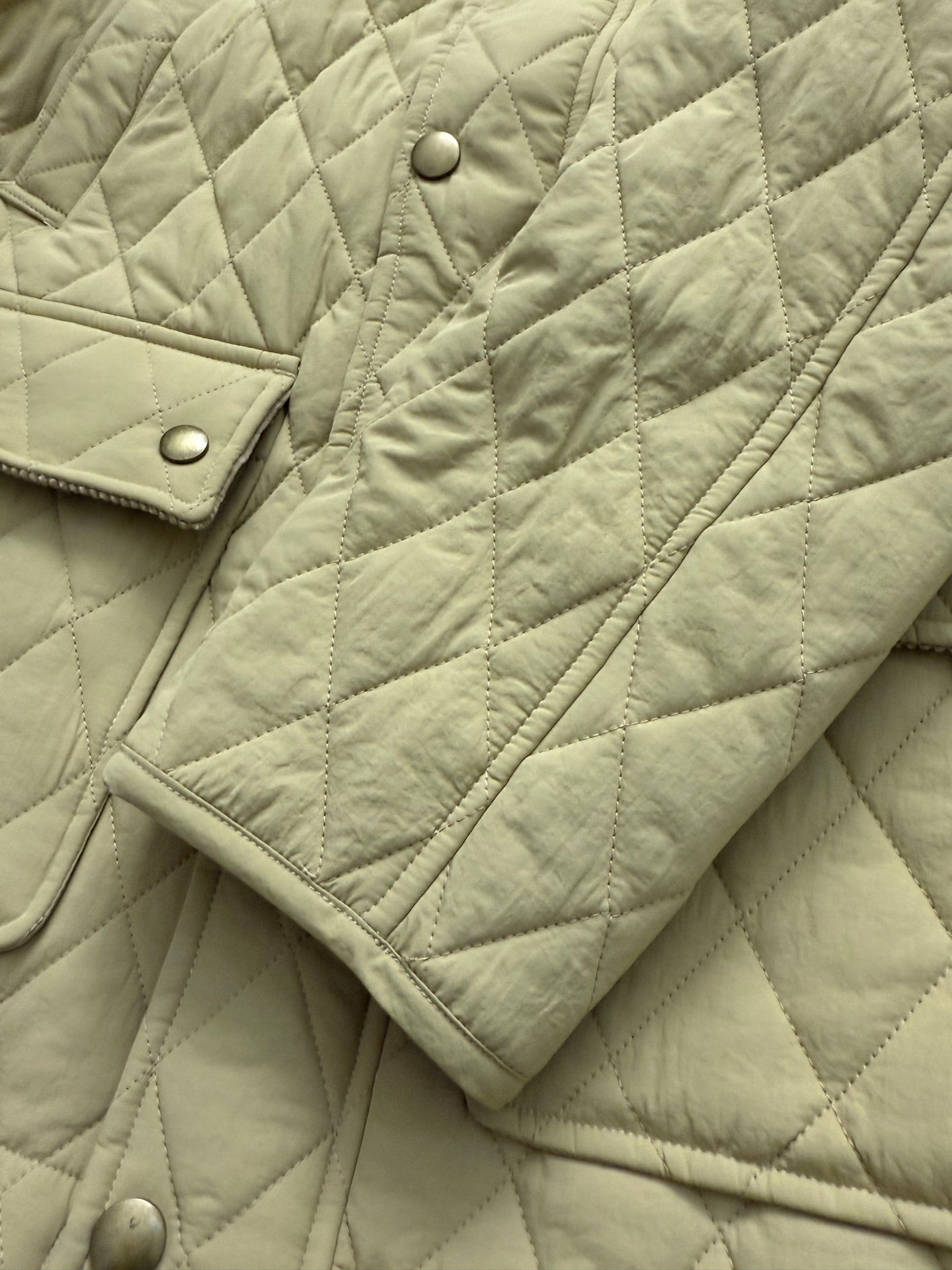 Light yellow quilted jacket sleeve with snap button placket detail