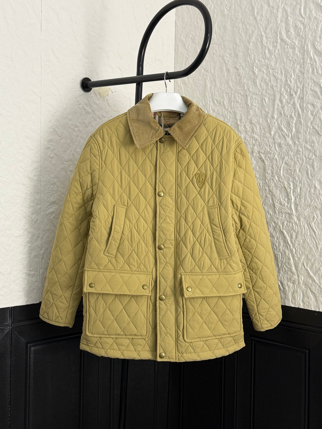 Yellow quilted kids jacket with button front and two flap pockets