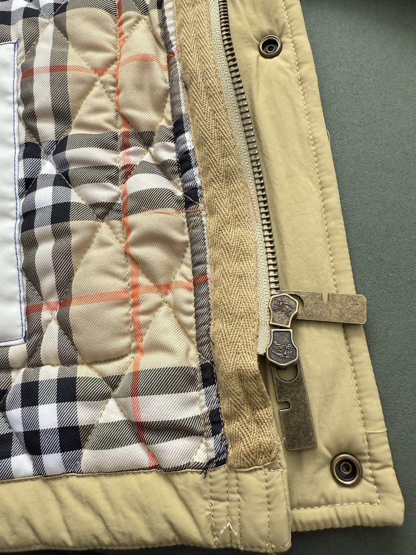 Light yellow quilted jacket cuff with zipper and plaid inner lining