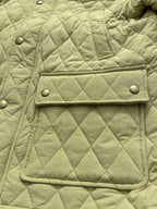 Light yellow quilted jacket front with flap patch pocket and snap buttons