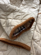 Quilted jacket pocket with plaid inner trim and tan braided edge cord border