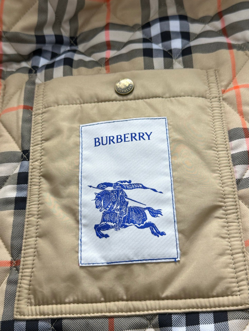 Burberry brand label patch on quilted jacket lining, with blue horse logo