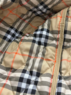 Plaid quilted lining with tan zipper seam and orange-red thread accents