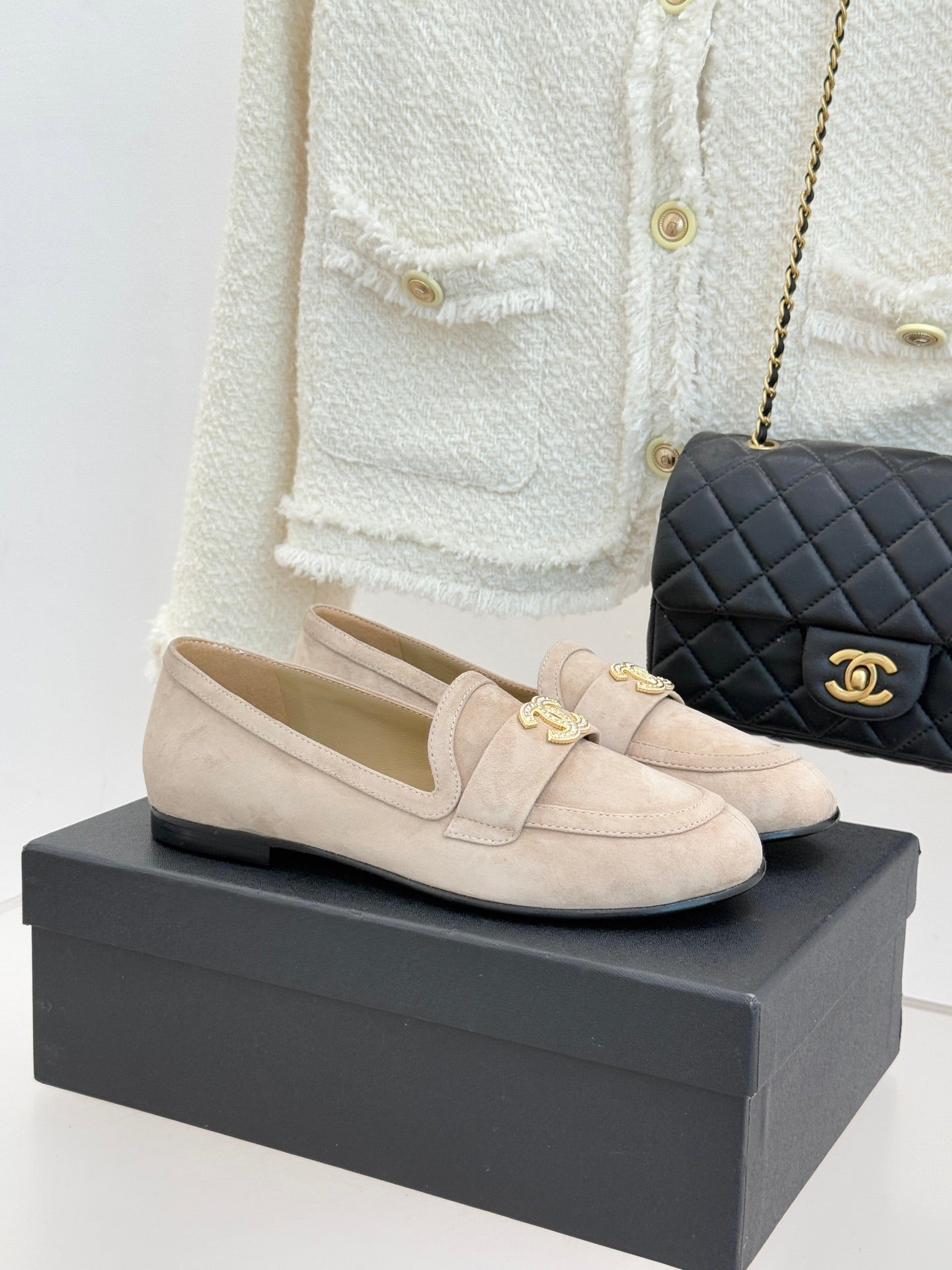 Beige suede loafer shoes with bow detail and gold-tone CC logo on front