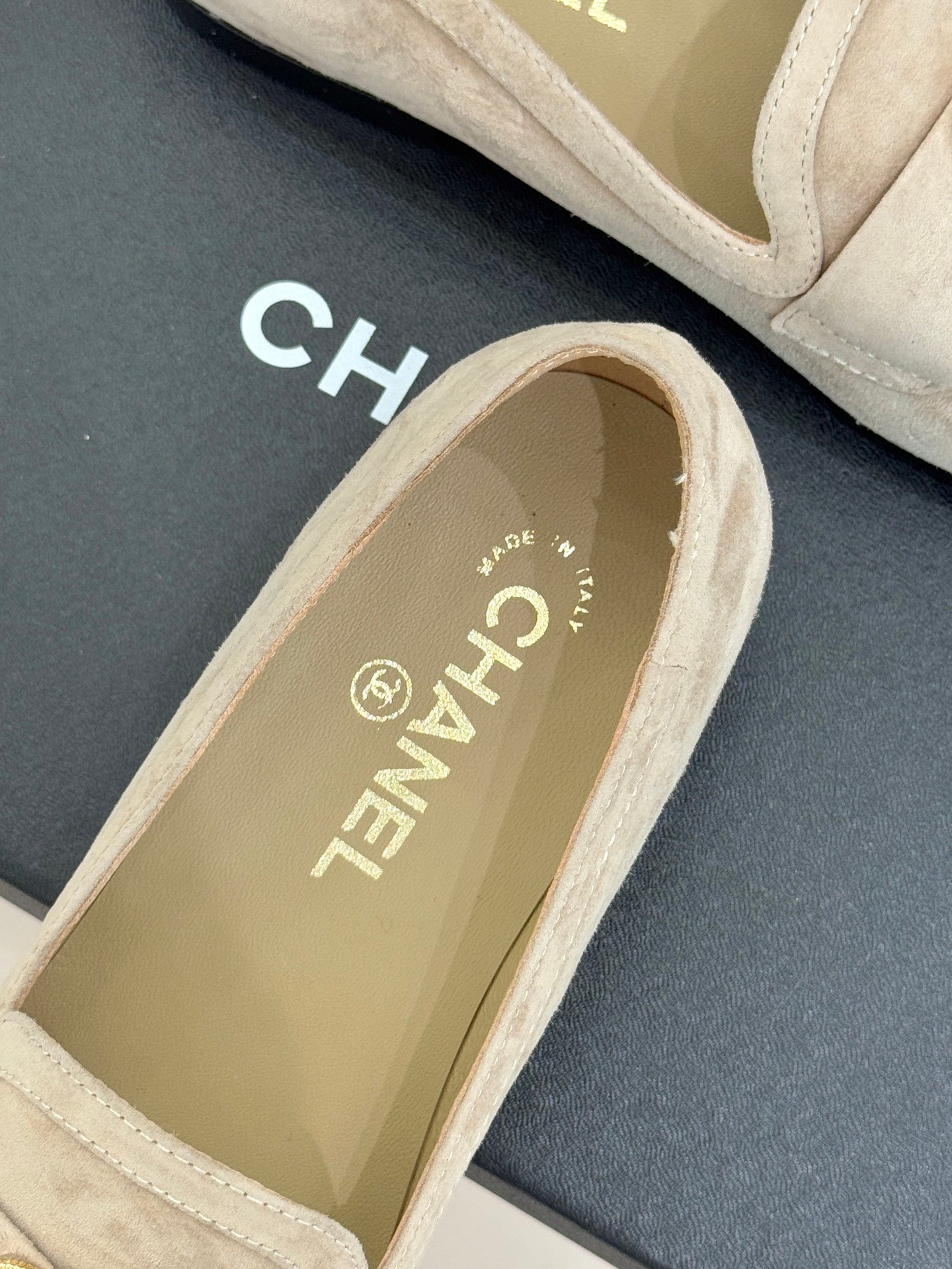 Beige suede loafer with gold CHANEL logo text on inner lining