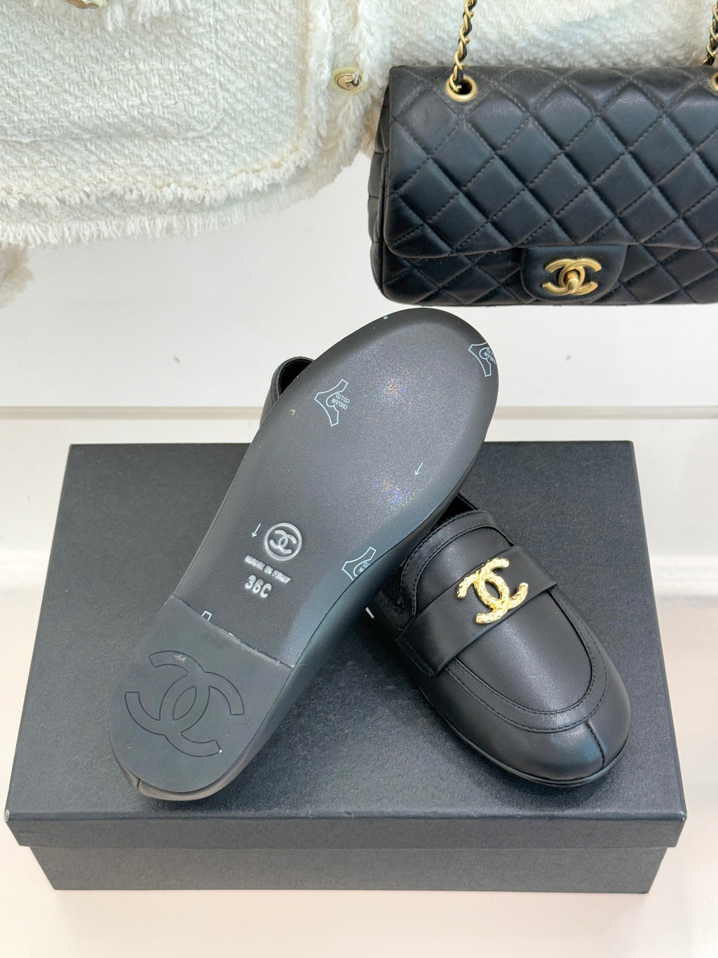 Chanel women’s black loafers with outsole view and gold CC logo on upper