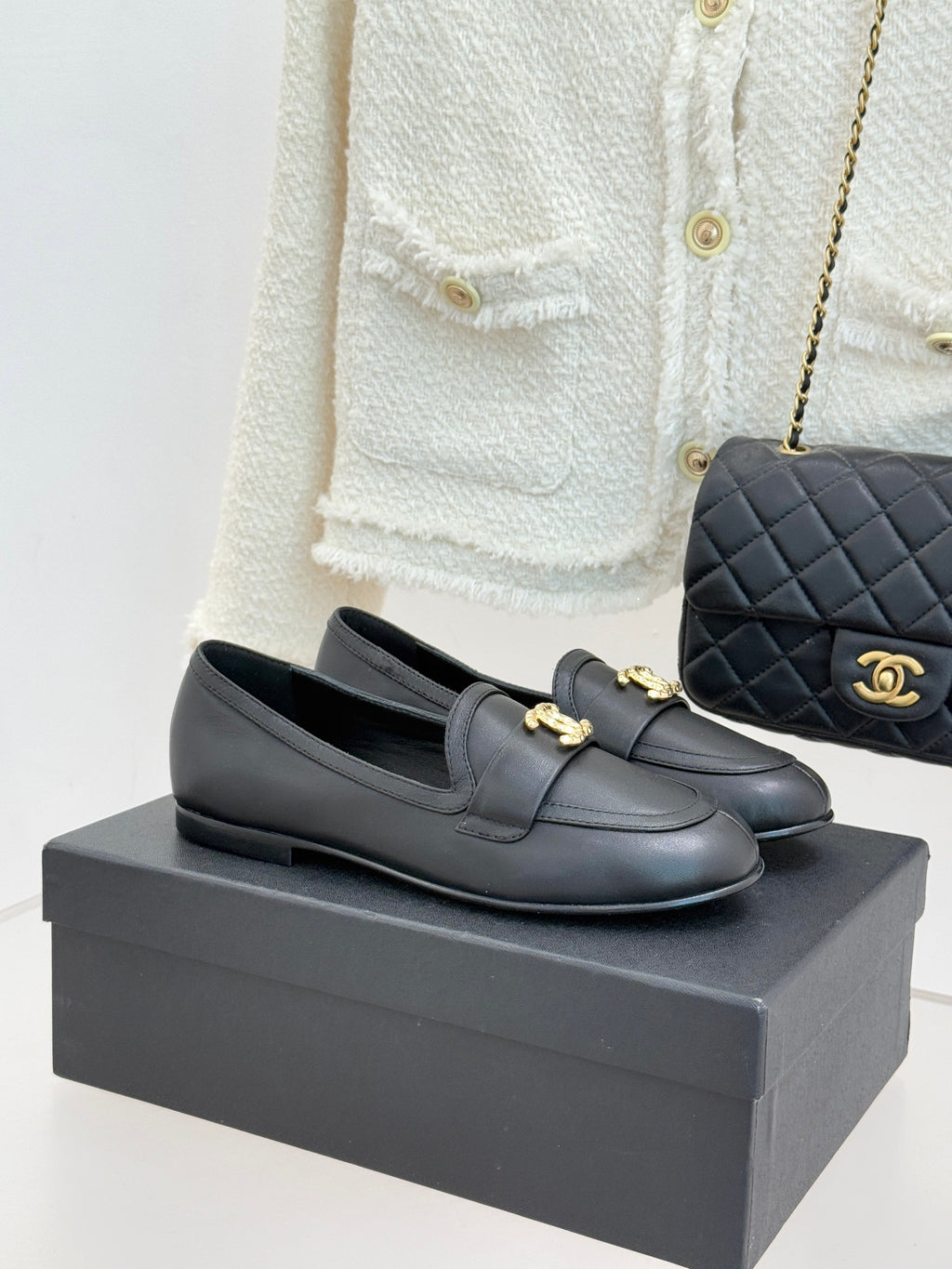 Chanel women’s black leather loafer with gold CC medallion on strap