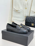Chanel women’s black leather loafer with gold CC medallion on strap