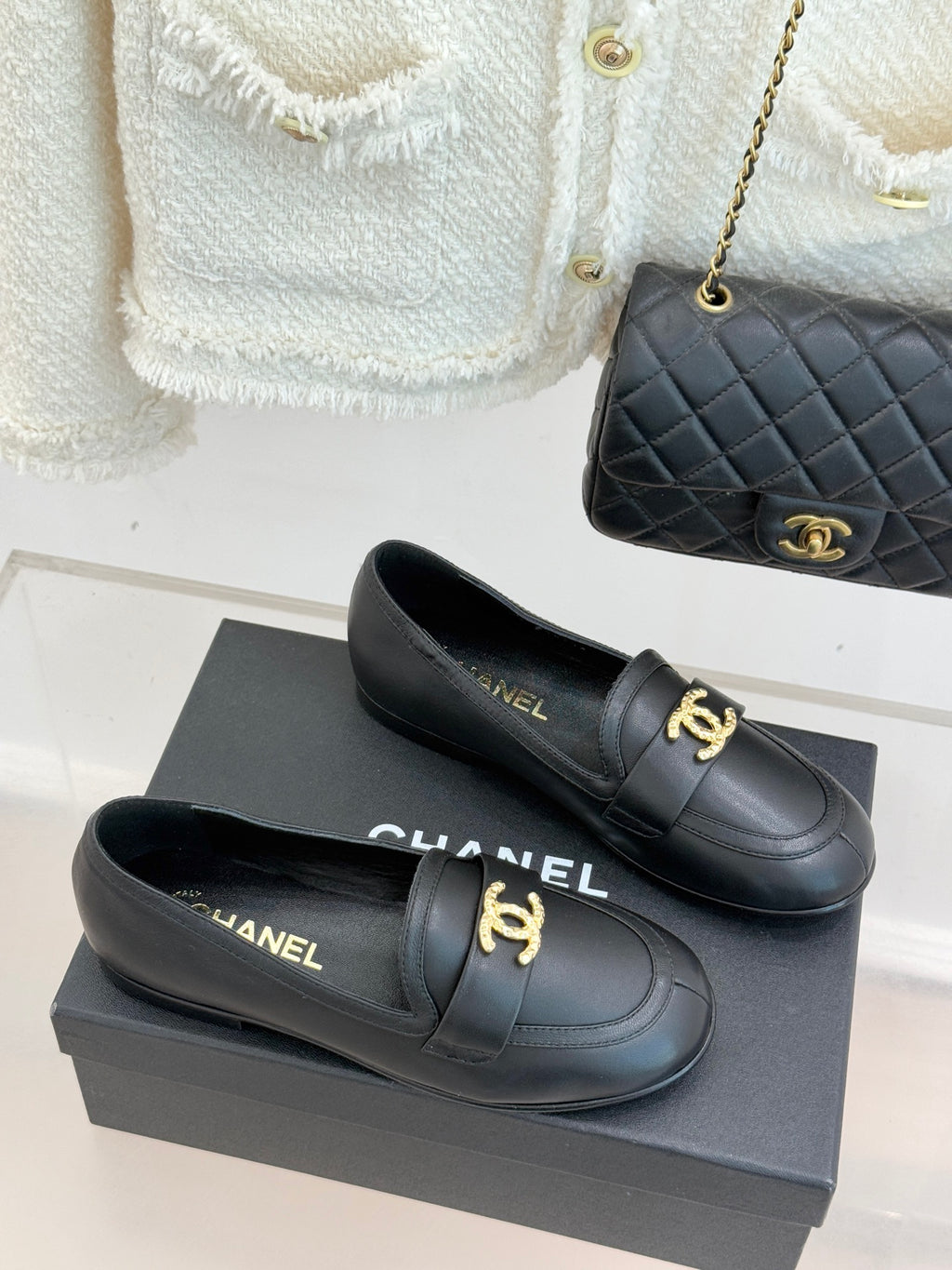 Chanel women’s black loafer shoes with gold CC accent and low heel, pair