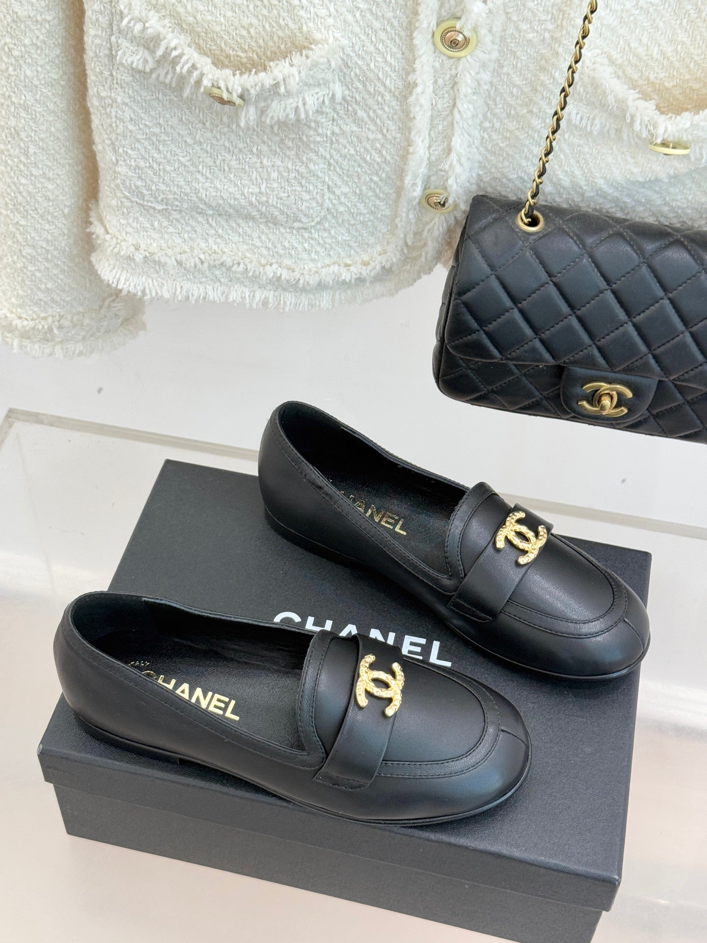 Chanel women’s black loafer shoes with gold CC accent and low heel, pair