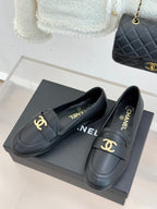 Chanel women’s dark loafers with gold logo buckle detail, pair on box