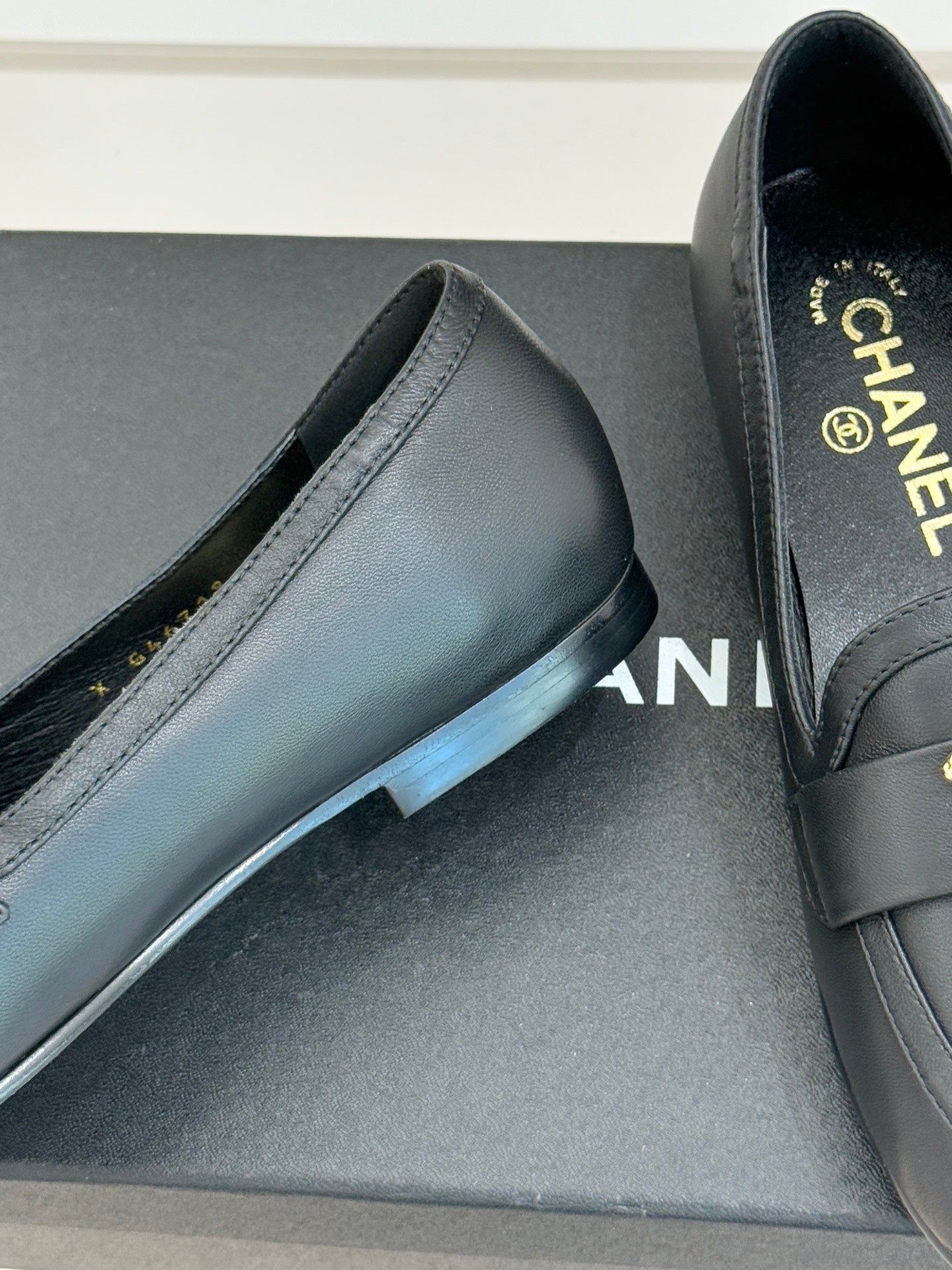Chanel women’s black leather loafer showing stitching and low heel, close-up