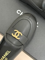 Chanel women’s black loafer close-up with gold CC emblem on front strap