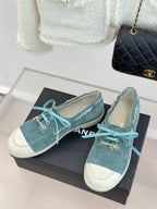 Chanel ladies blue suede sneakers on black box, teal laces and gold chain detailing