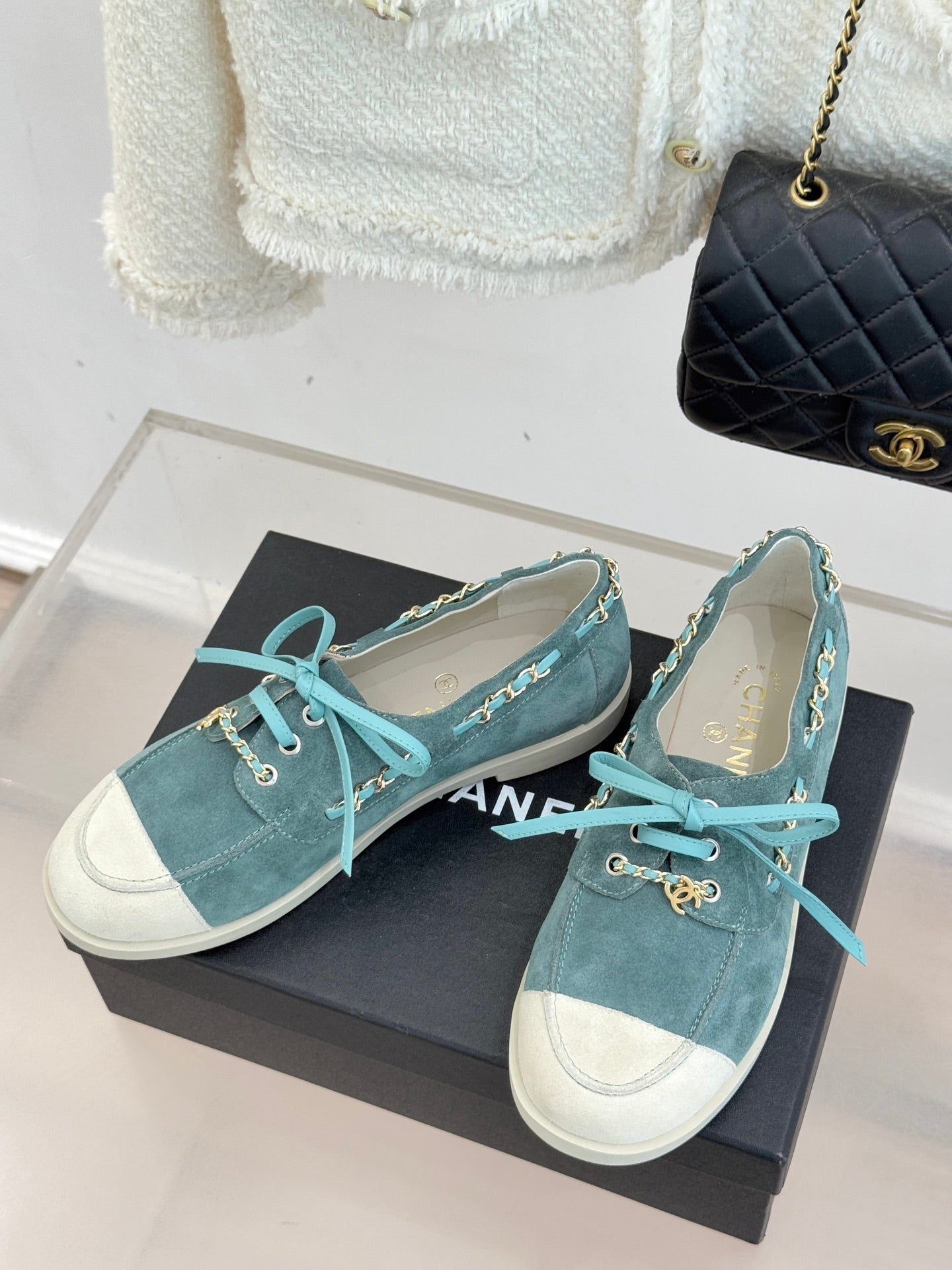 Chanel ladies blue suede sneakers on black box, teal laces and gold chain detailing