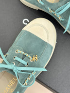 Chanel ladies blue suede sneakers close-up, gold chain horsebit detail and teal laces