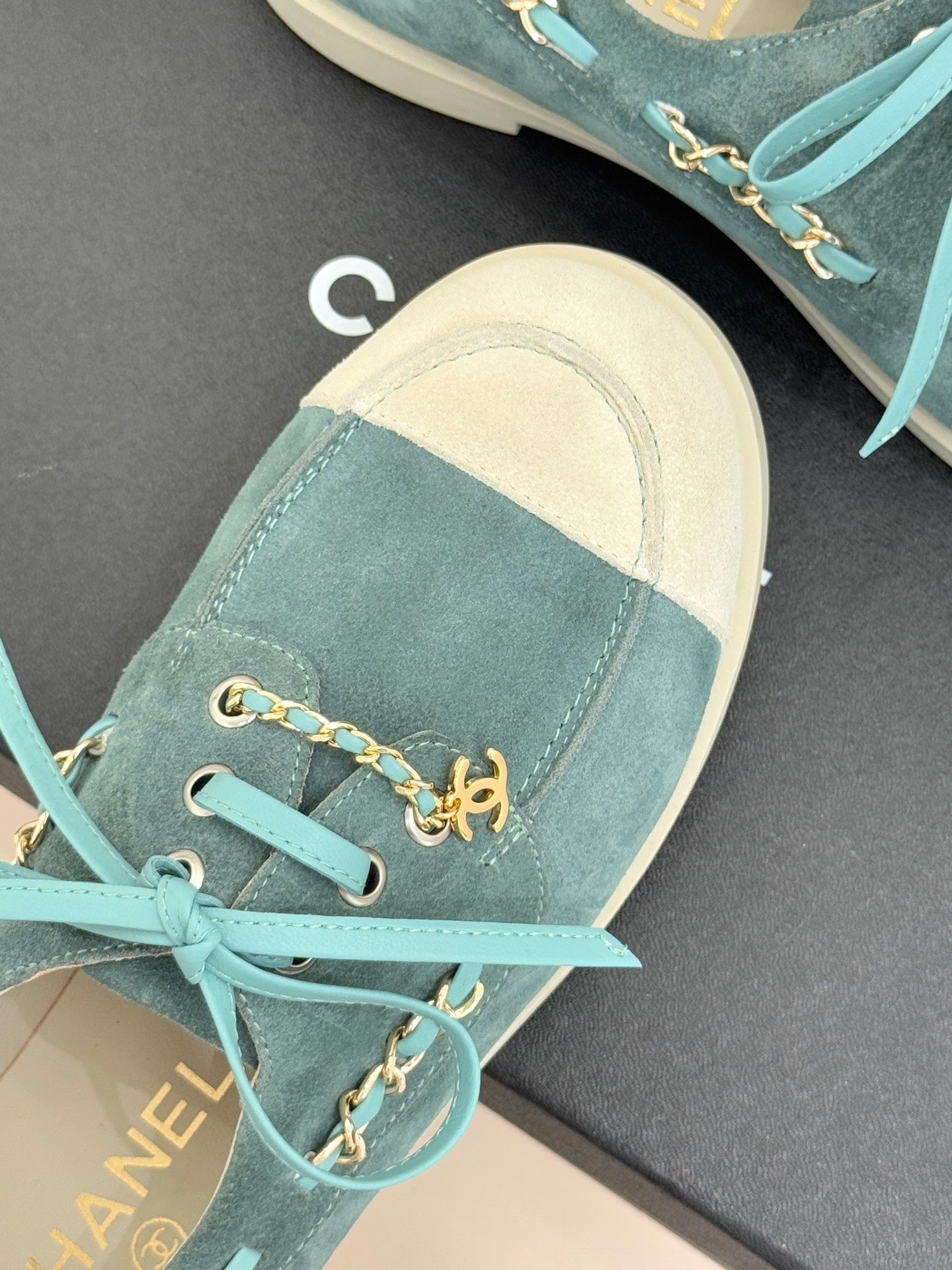 Chanel ladies blue suede sneakers close-up, gold chain horsebit detail and teal laces