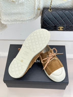 Tan suede lace-up sneakers showing treaded white rubber outsole and pink laces